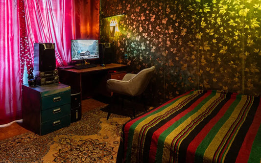 a bedroom with a bed, desk and television