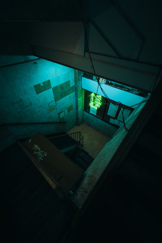 A dark room with a neon green door