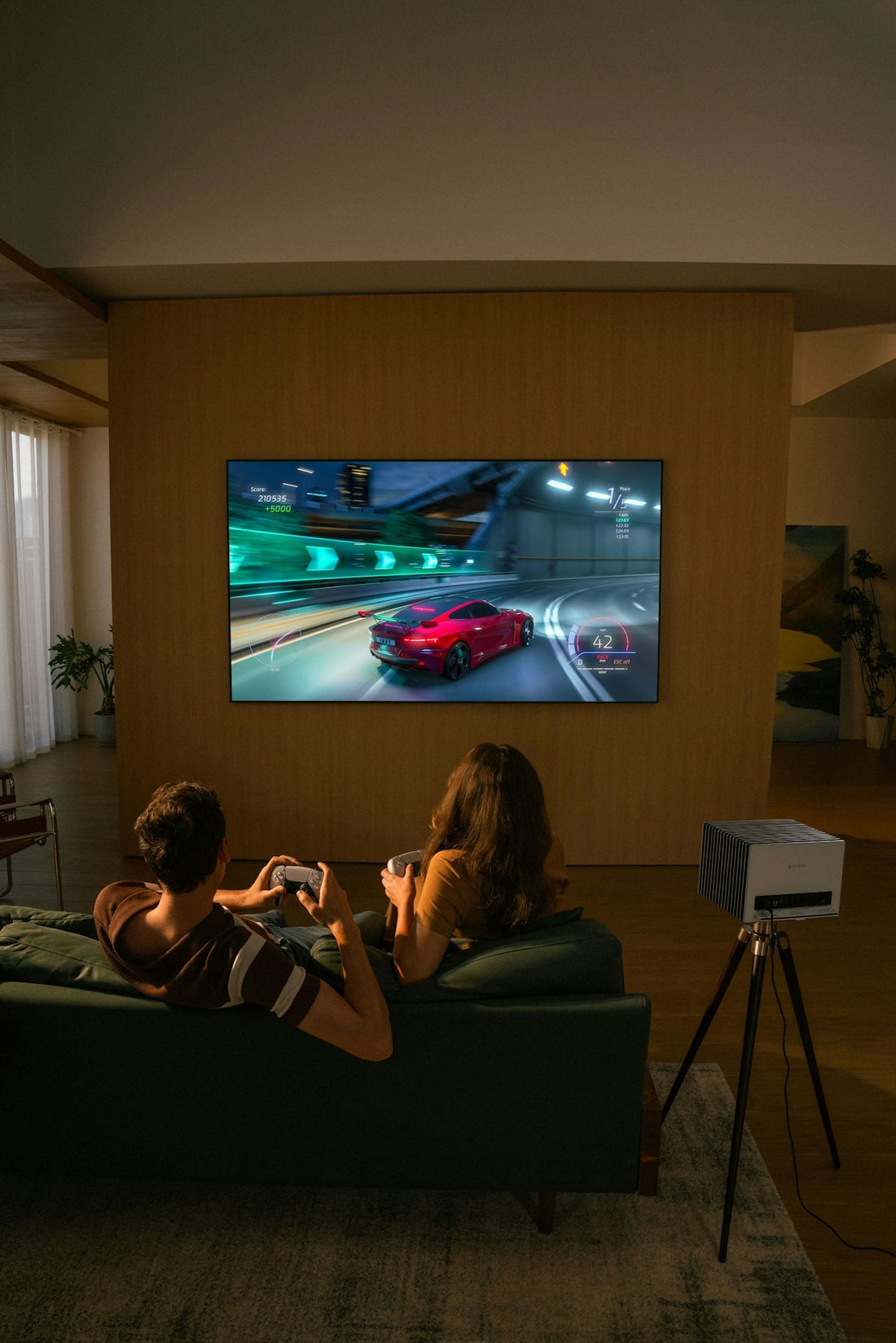 Two people playing a racing video game on television