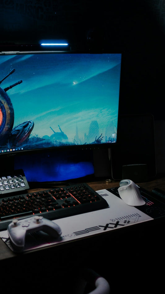 Gaming setup with illuminated keyboard and controller.