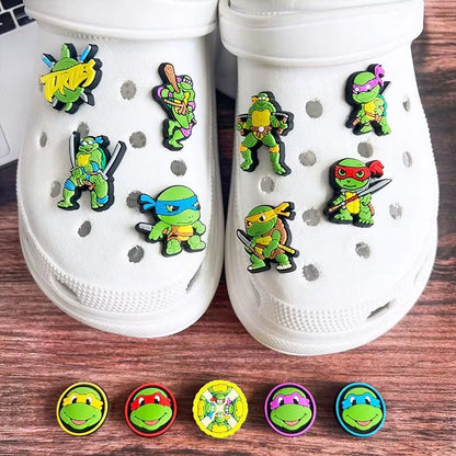 White clogs with Teenage Mutant Ninja Turtle-themed shoe charms on a wooden surface.