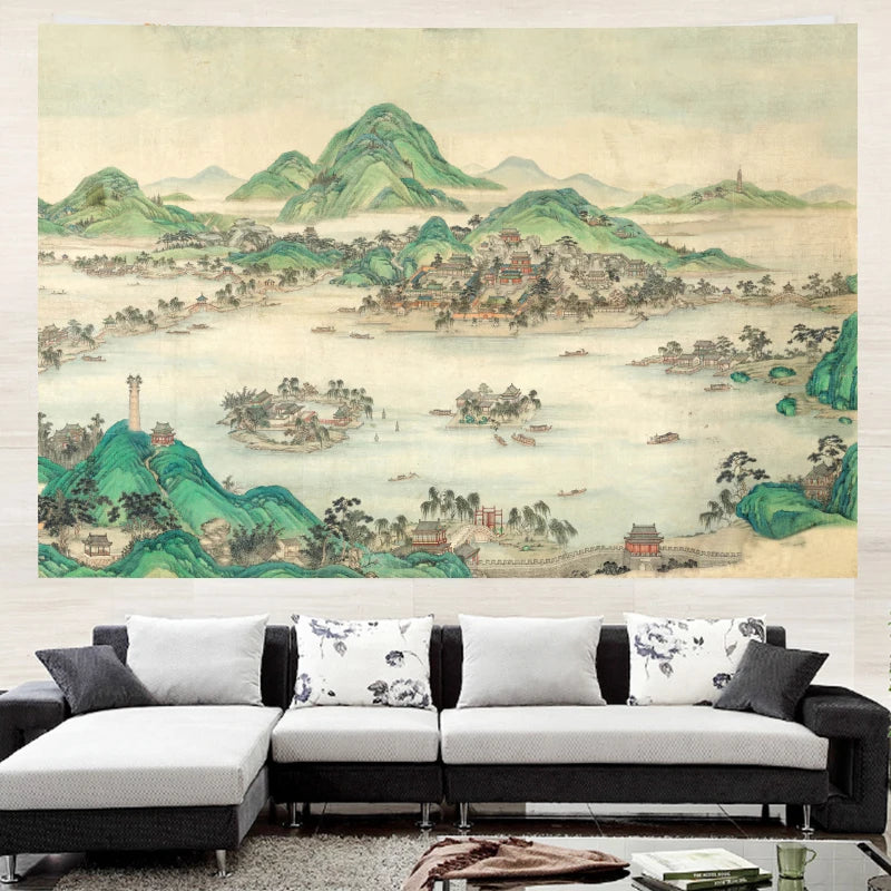 A large wall mural depicting a traditional Chinese landscape with green mountains, water, and small buildings, shown hanging above a modern white and black sectional sofa in a living room setting.