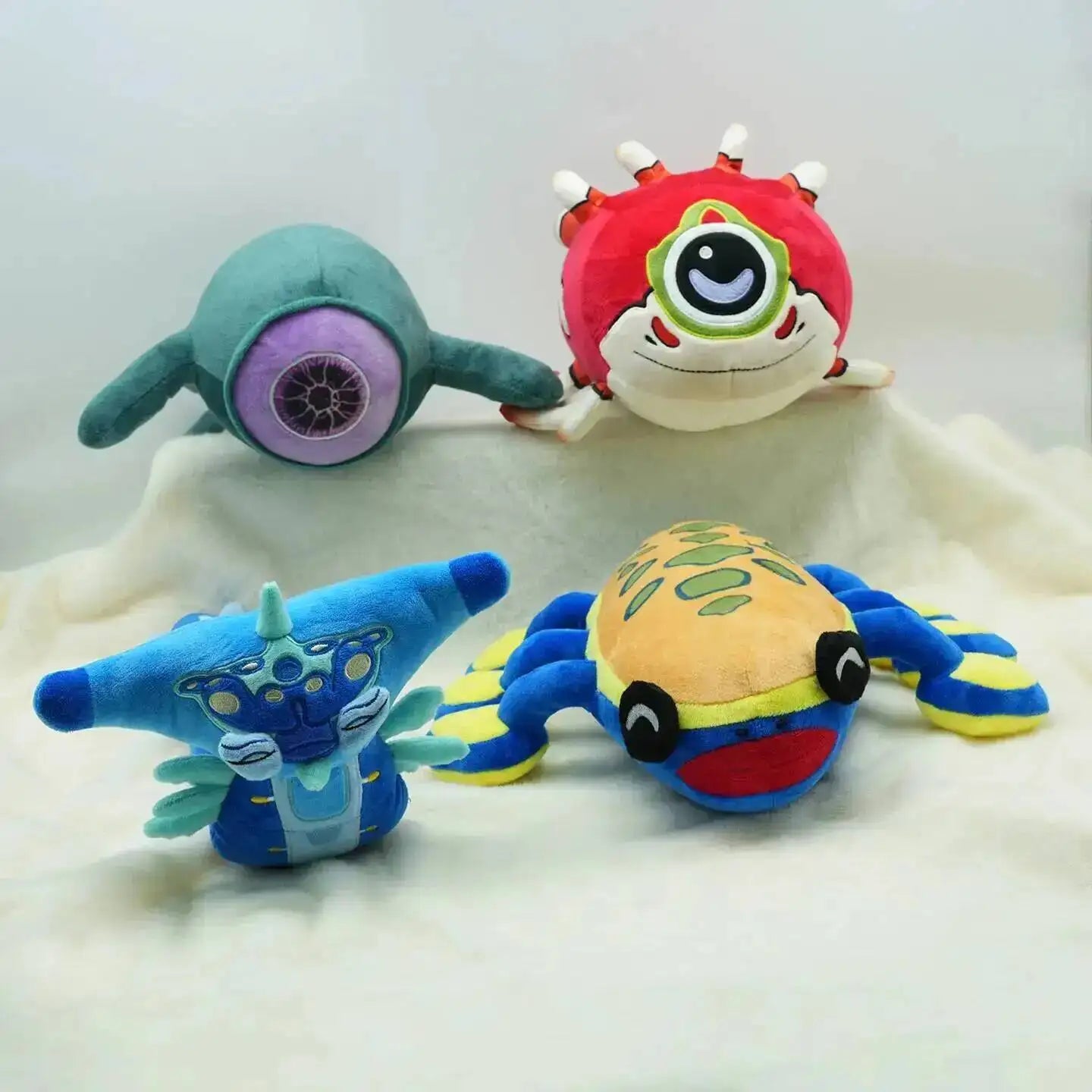 Four colorful plush toys on a white surface
