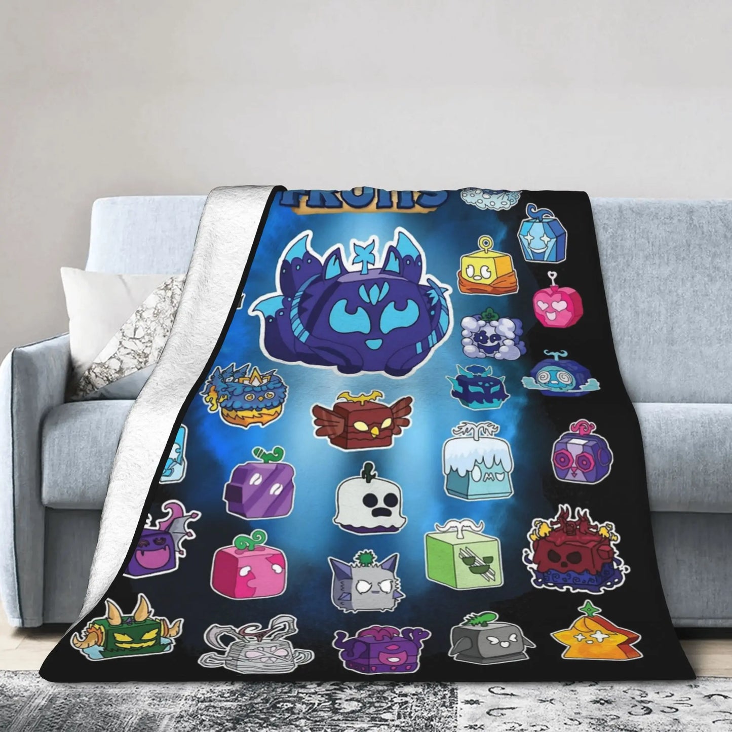 Colorful cartoon blanket with various characters on a gray couch.