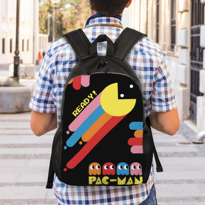 Person wearing a black backpack with Pac-Man design outdoors.