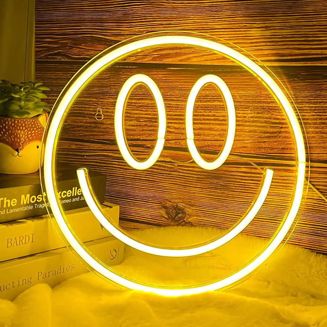 a smiley face light sitting on top of a pile of books