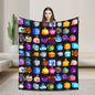 Person holding a colorful blanket with various cartoon-like icons on a black background.