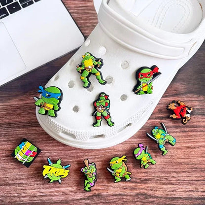 Set of Teenage Mutant Ninja Turtle pins on a white shoe with a laptop in the background.