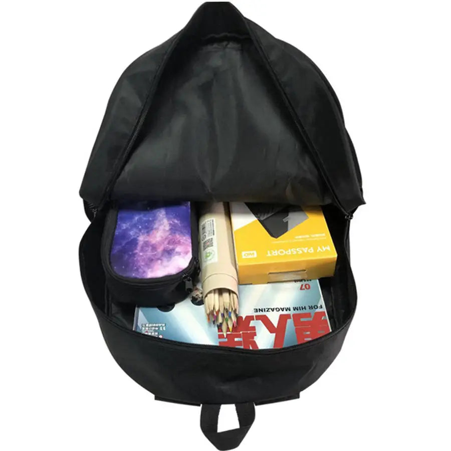 Black backpack with items including a magazine, a box, and a small container.
