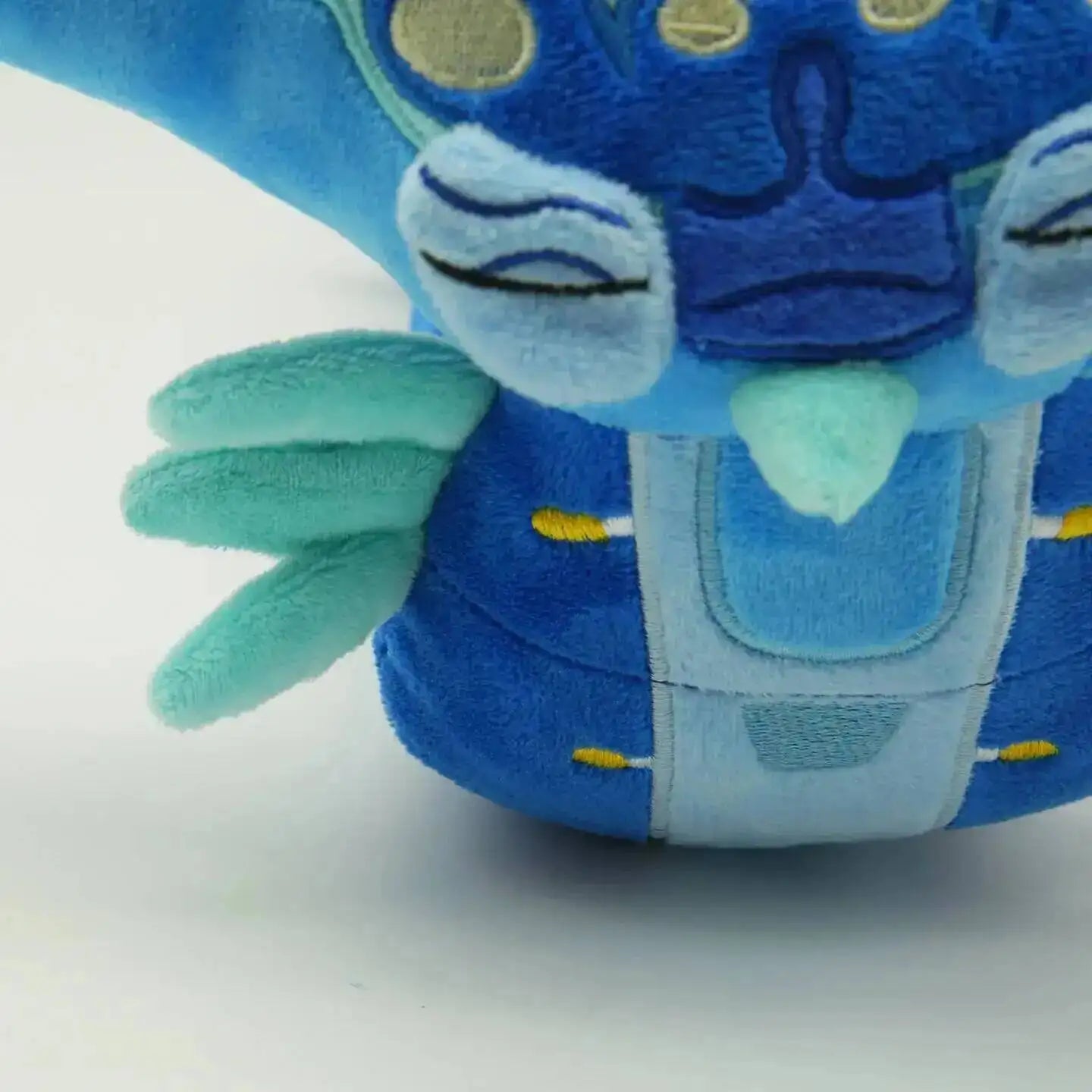 Blue plush toy with a crown on a white background
